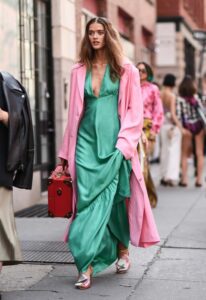 modelo con vestido verde y abrigo rosa