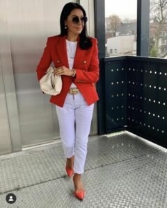 señora con blazer roja y pantalon blan