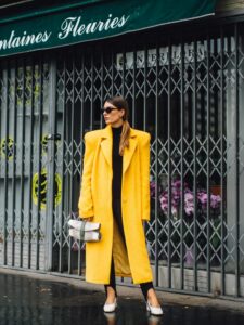 mujer con abrigo amarillo