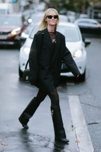 mujer con blazer larga y botas negras polaina